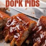 Baked pork ribs on a baking sheet. Overlay text reads, "Oven Baked Pork Ribs".