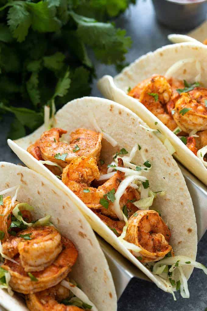 Shrimp tacos with cilantro lime slaw in a taco holder tray. 