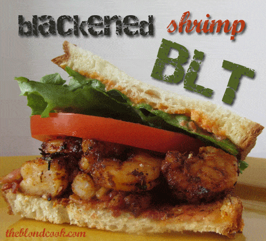 A closeup of a sandwich with shrimp, lettuce and tomato. Text at top of image.