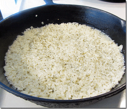 Cauliflower crust mixture in the bottom of a cast iron skillet.