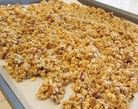 Granola on a baking sheet lined with parchment paper.