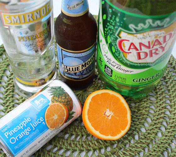 A bottle of vodka, beer, ginger ale, juice concentrate and a sliced orange.