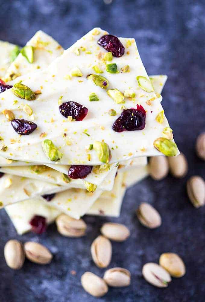 Angled overhead view of a stack of chocolate bark with dried cranberries and pistachios.