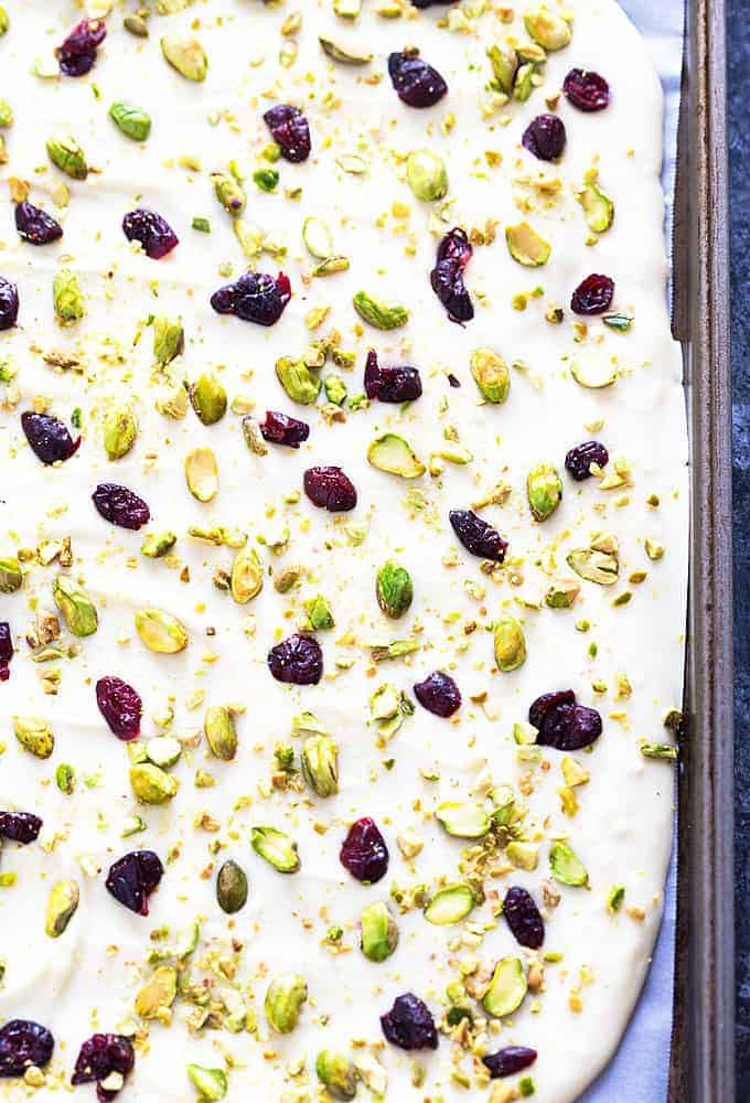 Overhead view of pistachio cranberry chocolate bark in a baking sheet.