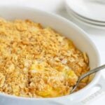 Squash casserole in a baking dish with overlay text that reads "cheesy squash casserole".