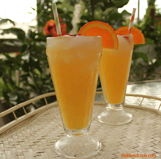 Two orange cocktails in soda glasses with paper straws on a serving tray.