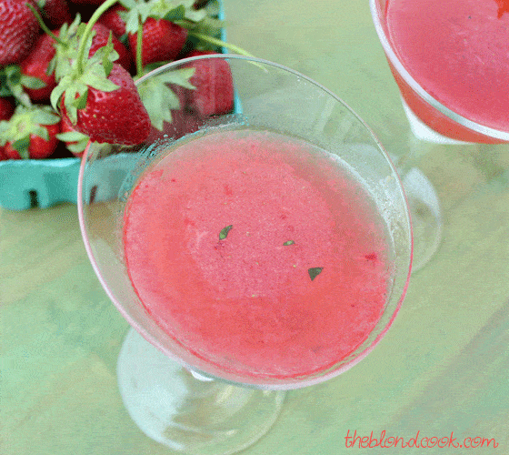 Overhead view of a strawberry martini in a martini glass garnished with a fresh strawberry.