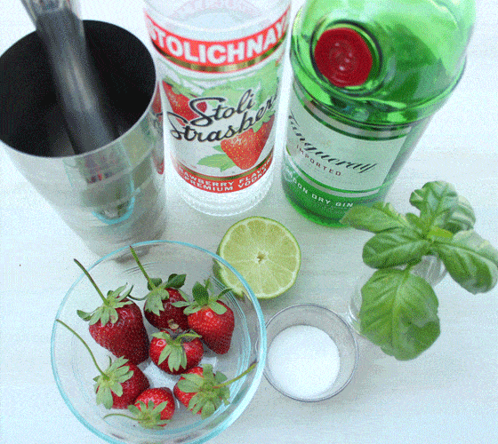 A cocktail shaker with a muddler, rum, gin, strawberries, lime, basil and sugar.