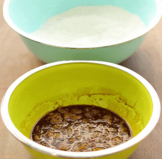 A blue bowl with dry ingredients and a green bowl with wet ingredients for dog treats