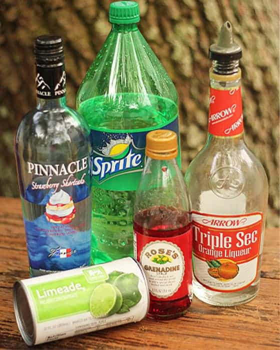Bottles of vodka, lemon lime soda, grenadine, orange liqueur and a container of limeade concentrate.