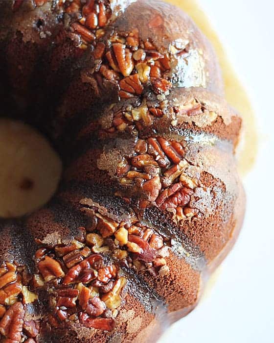 Overhead closeup view of a chocolate bundt cake with pecans and glaze.