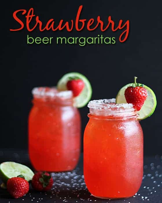 Two strawberry margaritas garnished with strawberry and lime on a black background. Text at top of image.