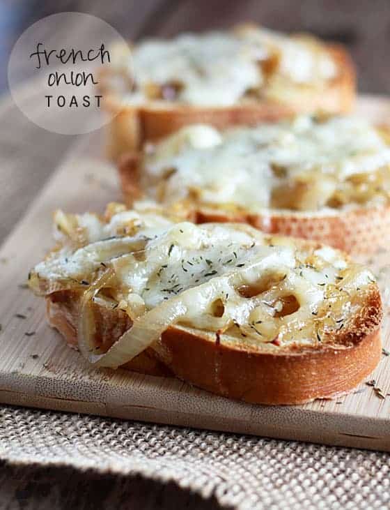 Sliced french bread with cooked sliced onions and melted cheese on top. Text at top left of image.