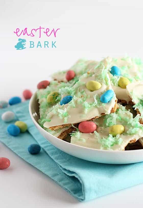 A white bowl filled with Easter bark candy on a folded blue napkin.  Text at top left of image.