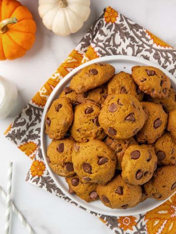 Overhead view of pumpkin chocolate chip cookies on a round white plate