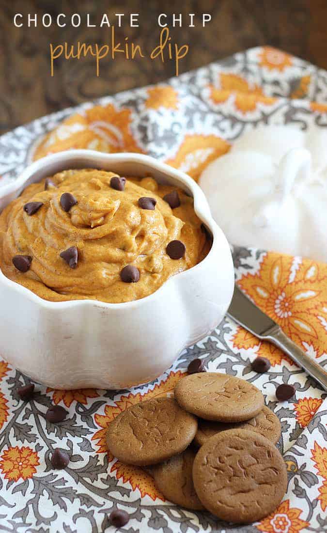 Pumpkin dessert dip with chocolate chips in a white decorative bowl on a patterned napkin.