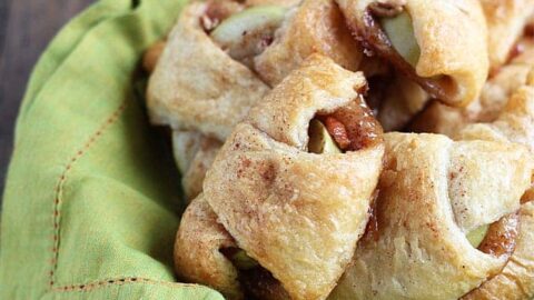Apple pie bites in a bowl with a green napkin.