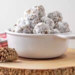 Date balls in a white bowl on a wooden trivet