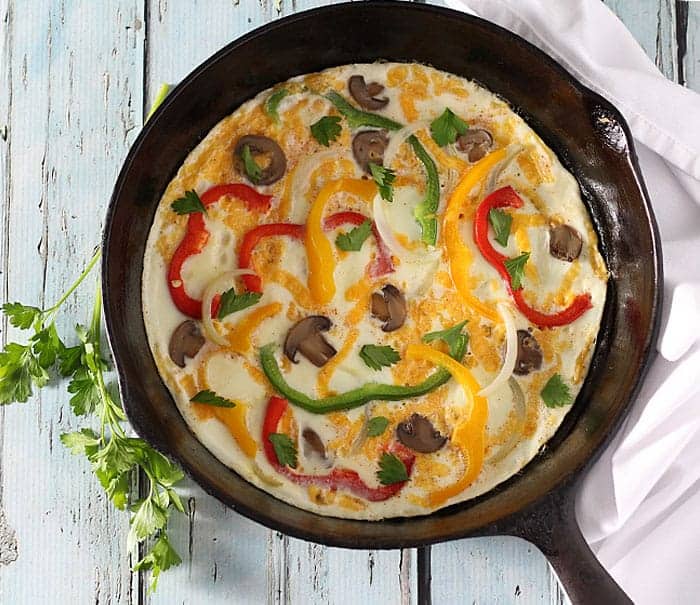 Overhead view of a frittata prepared with egg whites and veggies in a cast iron skillet.