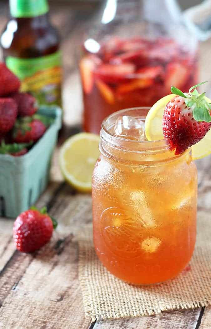 Beer lemonade with strawberries in a mason jar garnished with a strawberry and lemon slice.