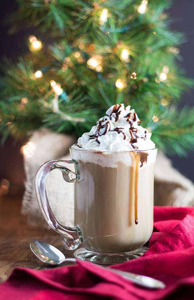 A coffee cocktail topped with whipped cream.  A Christmas tree is in the background.