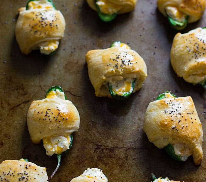 Overhead closeup view of baked jalapeno crescent roll appetizers on a baking sheet.