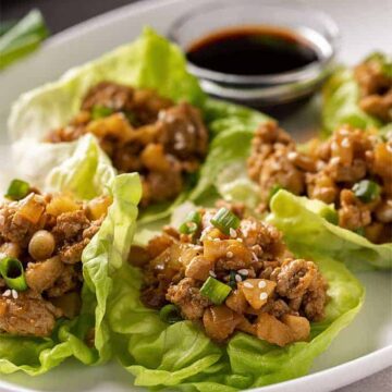 Lettuce wraps with ground chicken on an oval white plate