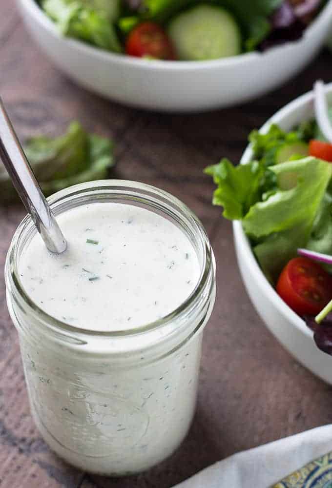 Overhead closeup view of salad dressing in a jar with a spoon.