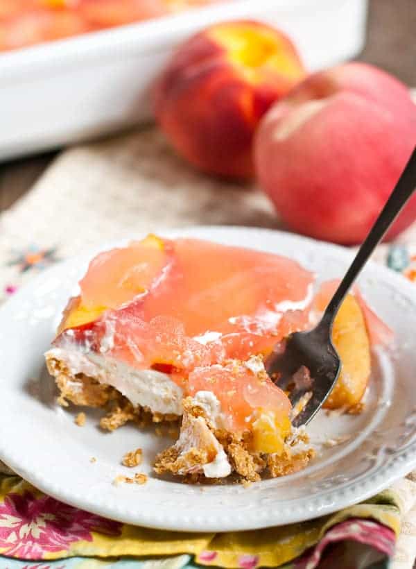 No Bake Peach Delight dessert on a white plate with a fork. 