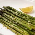 Baked asparagus with garlic on an oval white plate