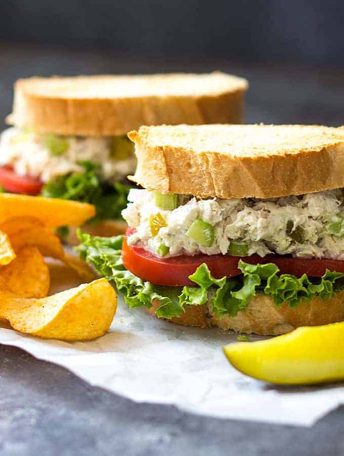 Front view of two wahoo fish salad sandwiches with lettuce and tomato.