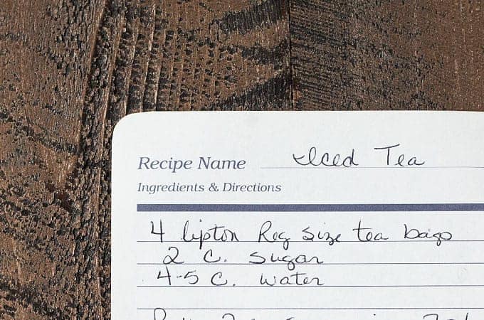A handwritten recipe for iced tea on paper from a recipe book.