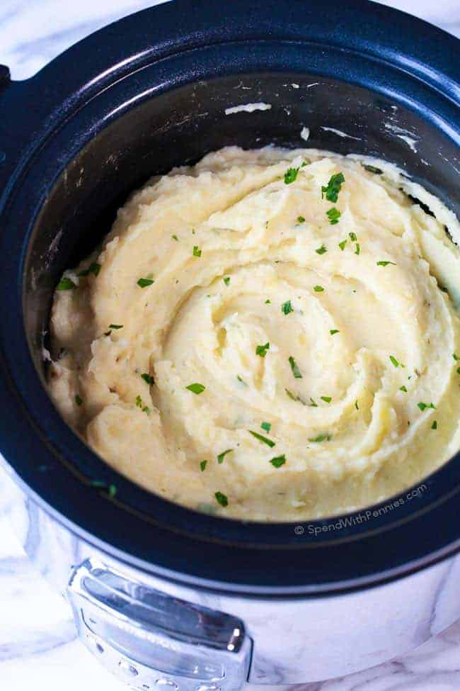 Overhead view of mashed potatoes in a round slow cooker.
