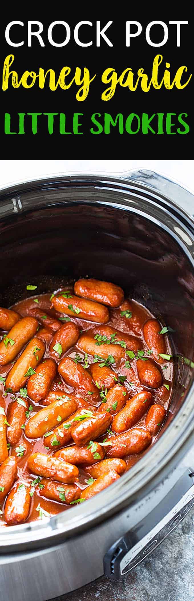 Cocktail sausages in sauce topped with chopped parsley in an oval slow cooker.