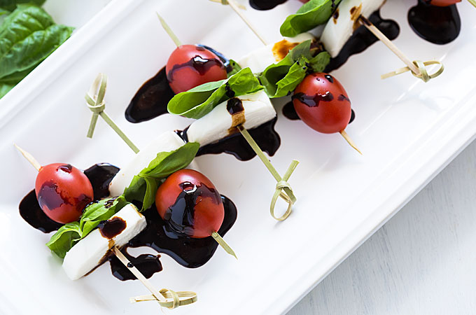 Overhead view of caprese bites drizzled with a balsamic reduction.