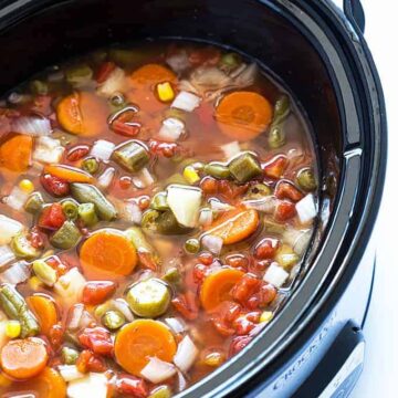 Closeup view of vegetable soup in an oval slow cooker.