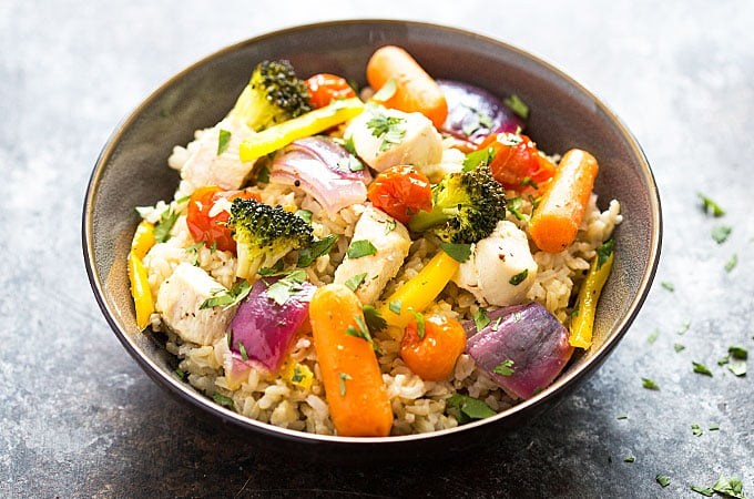 A gray bowl of rice topped with chicken and vegetables.