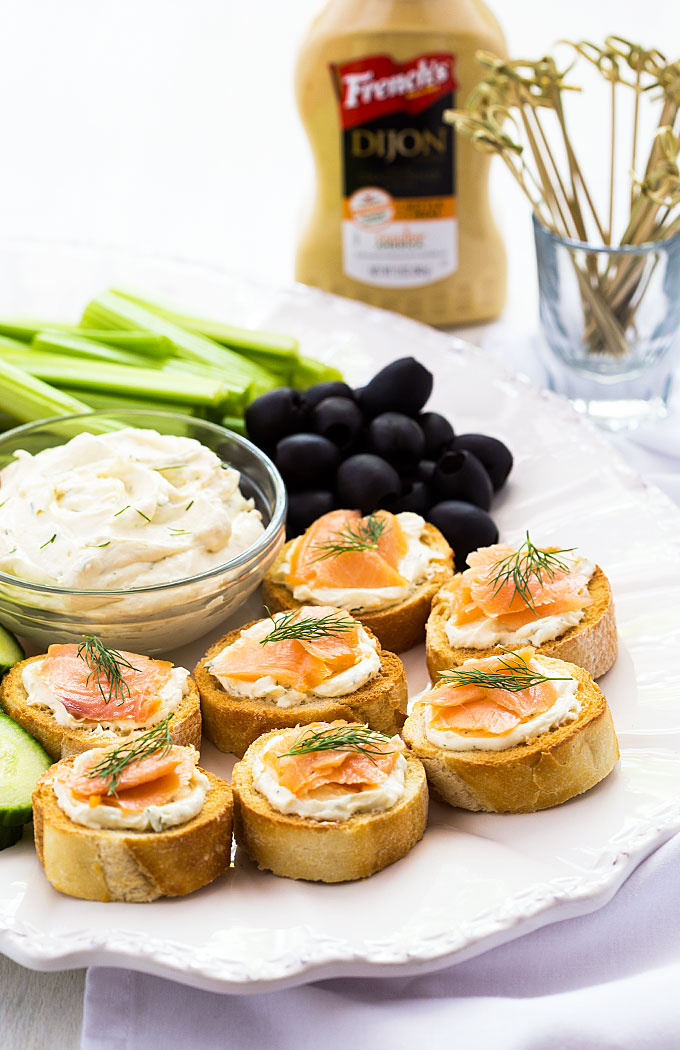 Smoked salmon appetizer, olives and vegetables on a platter with cream cheese spread.