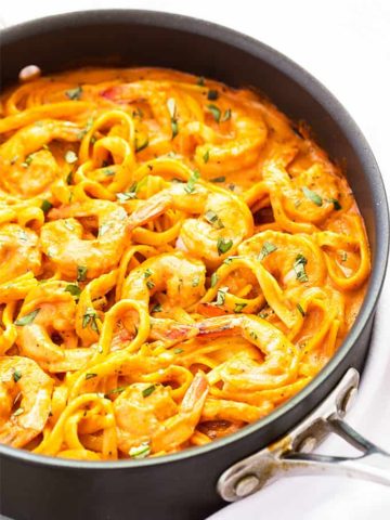 Shrimp and pasta in a tomato cream sauce in a skillet.