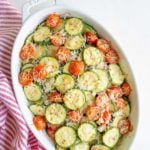 Baked zucchini and tomatoes in a white dish. Overlay text reads "zucchini tomato bake".