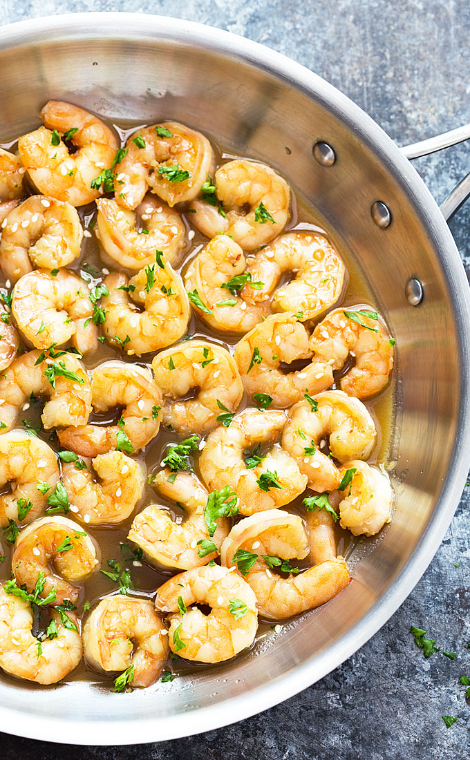 Overhead view of shrimp in a honey garlic butter sauce in a skillet.