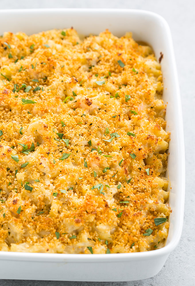 Mac and cheese with shrimp and crab meat topped with bread crumbs in a baking dish.