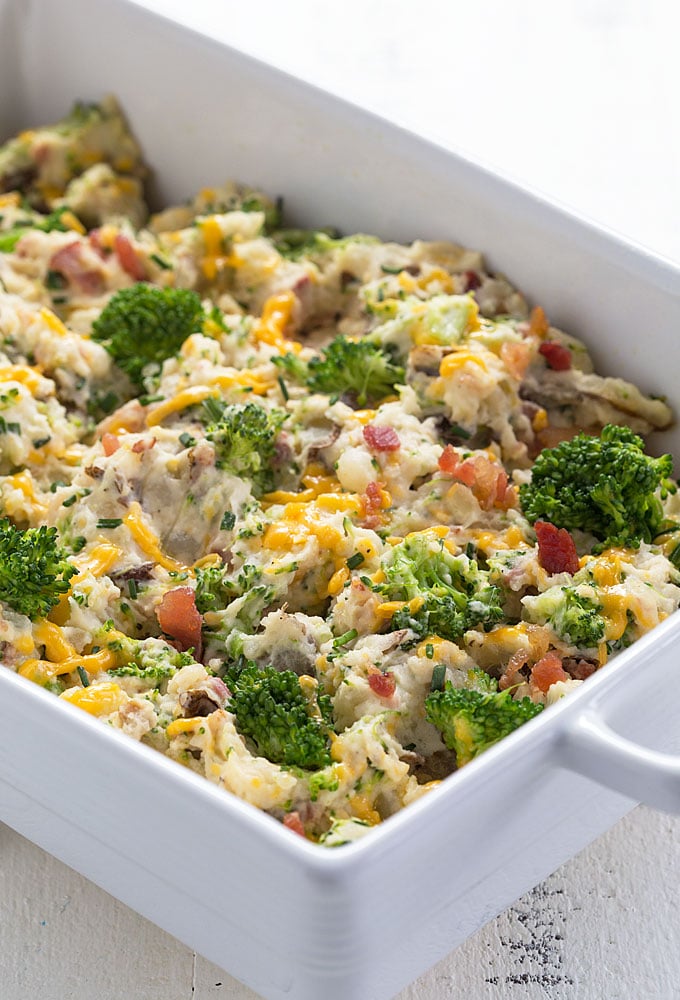 Broccoli cheese potato casserole in a white baking dish.