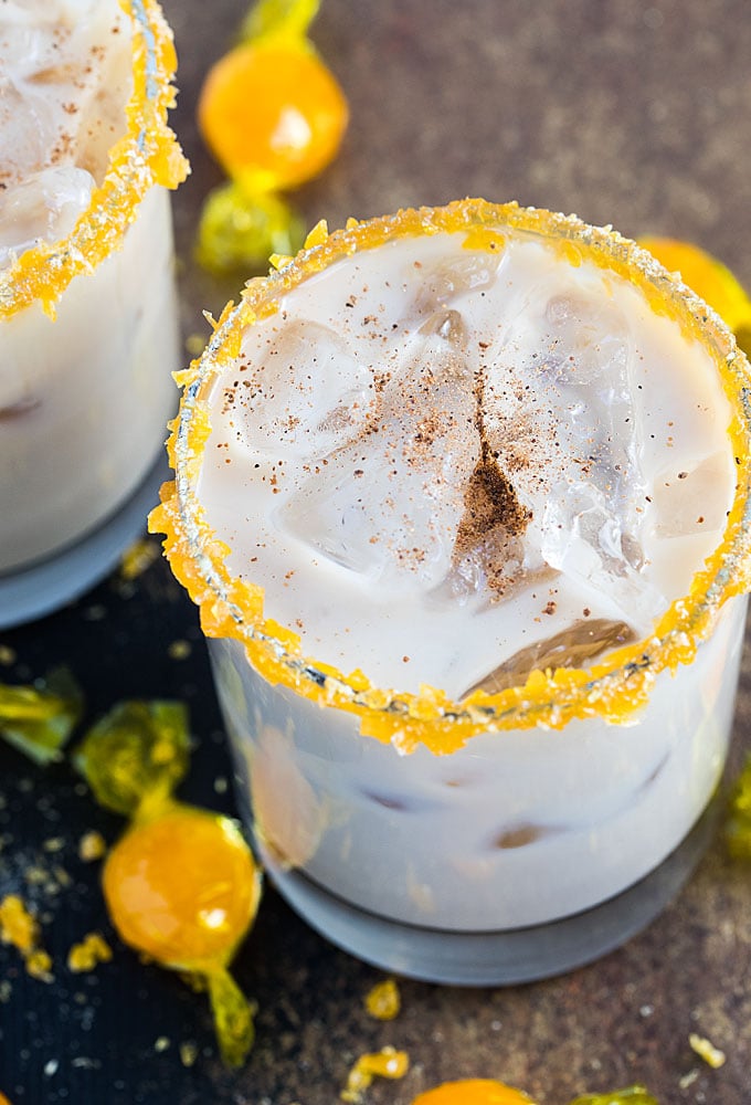 A closeup of a white russian in a glass rimmed with crushed butterscotch candy.