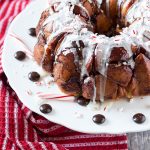Peppermint monkey bread on a white plate beside a red striped napkin.