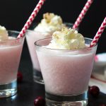 Front view of three frozen pink cocktails topped with whipped topping.