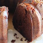 A closeup of a chocolate bundt cake with a slice removed.