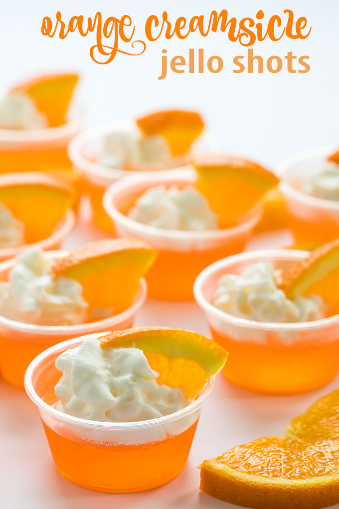 Front view of jello shots garnished with orange slices and whipped topping.