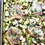 Baked pork chops with asparagus and potatoes in a sheet pan.