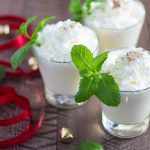 Three cocktails topped with whipped topping and garnished with mint sprigs.